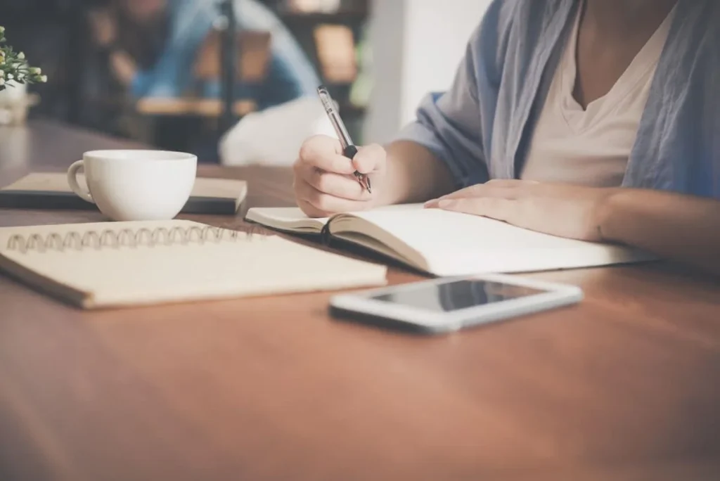 photo of a woman writing in a notebook