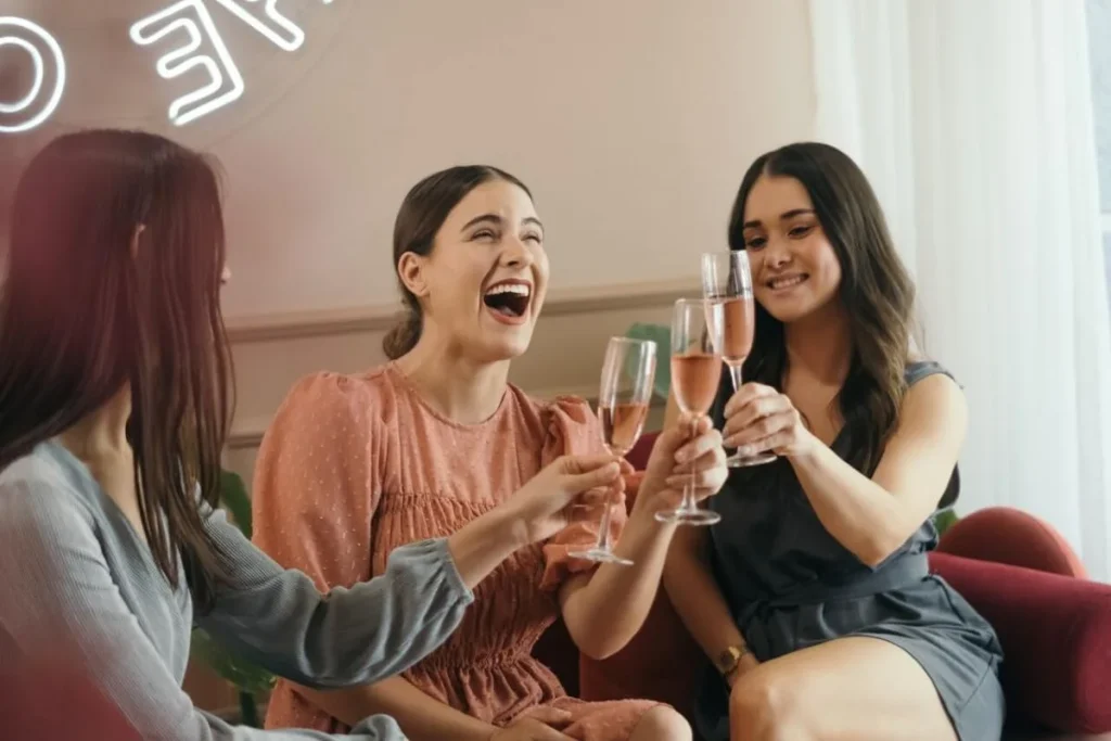 photo of two girls sharing a drink