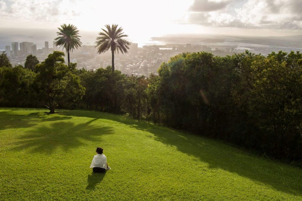 Discover why wellness communities are the future of real estate l A person sitting on a lush green field